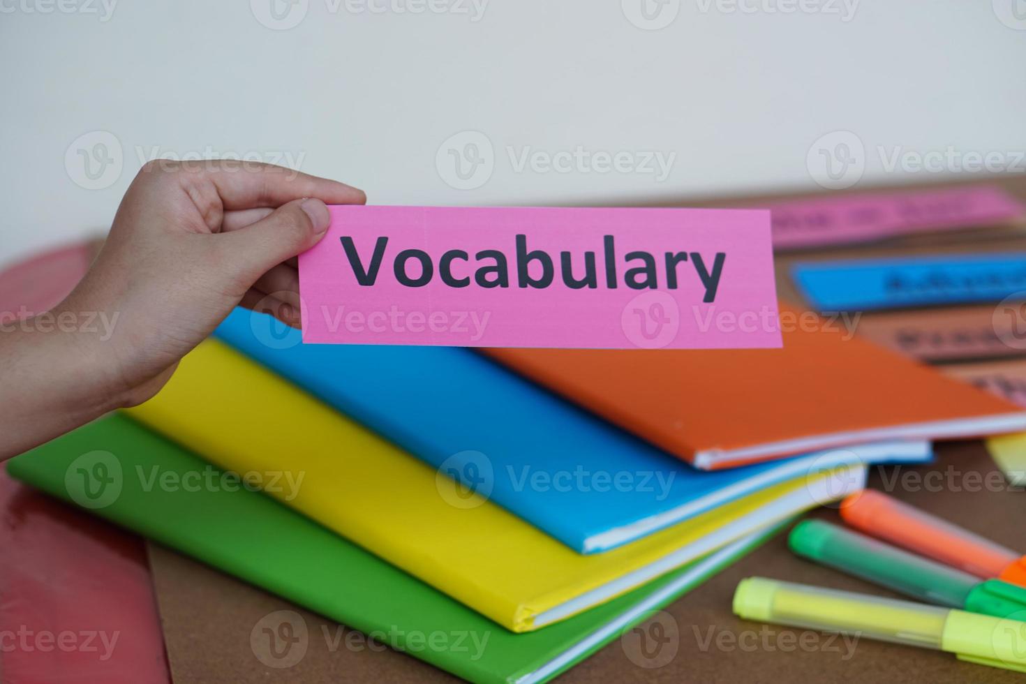 Closeup student's hand hold English vocabulary word card. Concept, education, learning, studying language. Education. Reading and memorizing strategy of learning process for kid. Practice make perfect photo