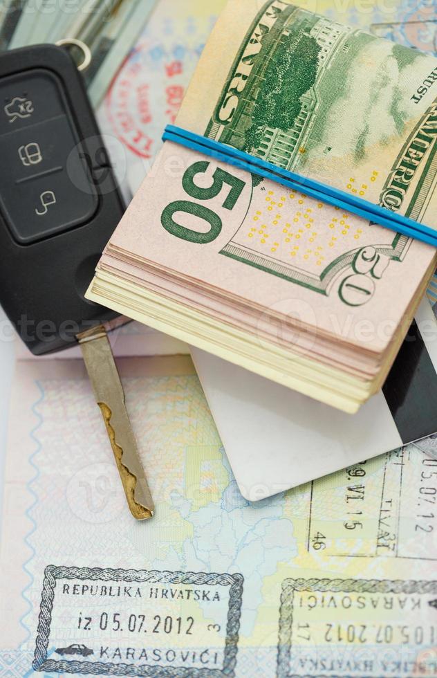 American money, credit cards and car key lies on thr top of the opened passport photo