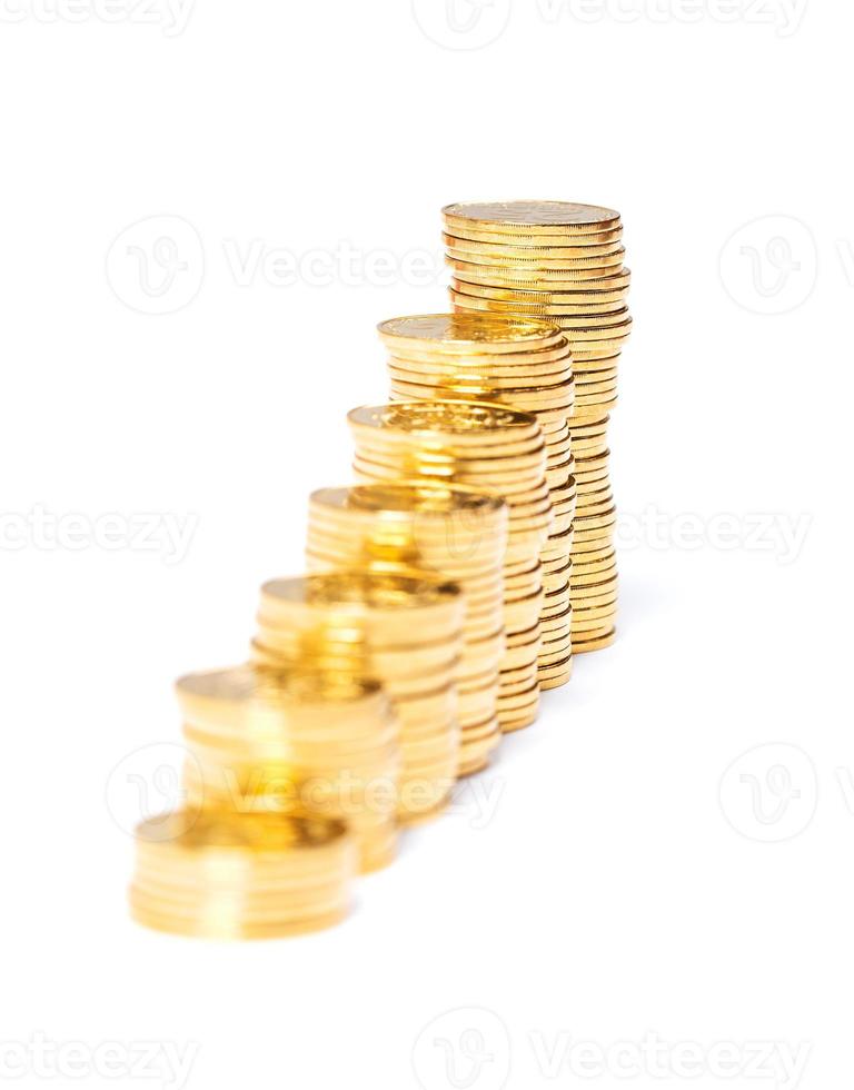 Columns of golden coins on white photo