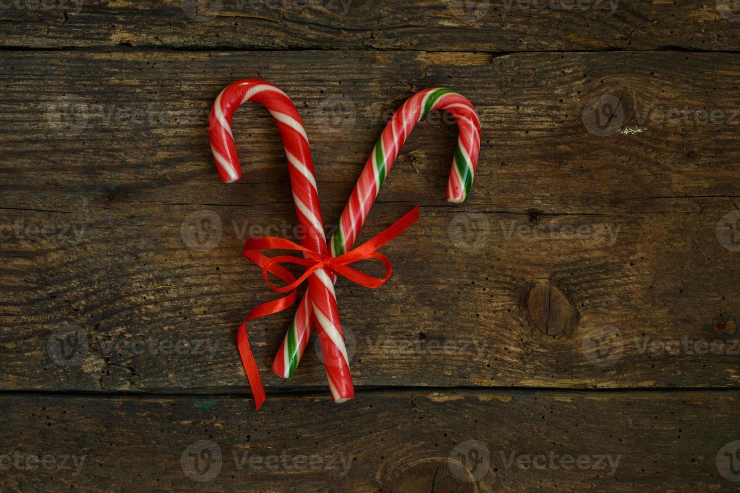 Closeup of two old fashioned candy canes on a rustic wooden background photo