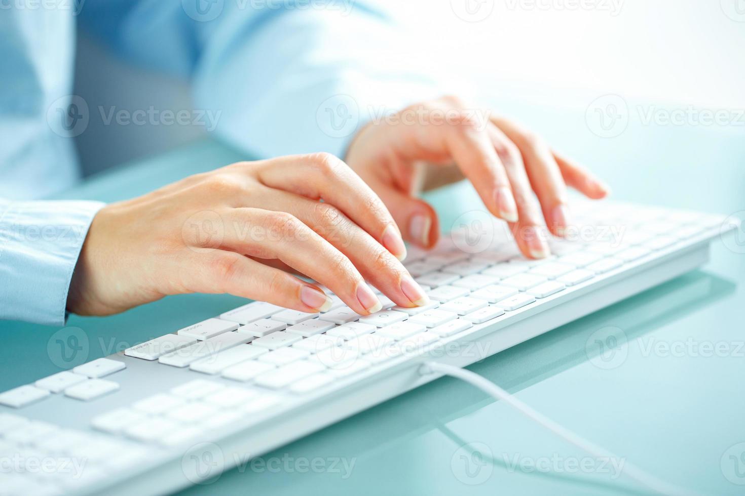 Woman office worker typing on the keyboard photo