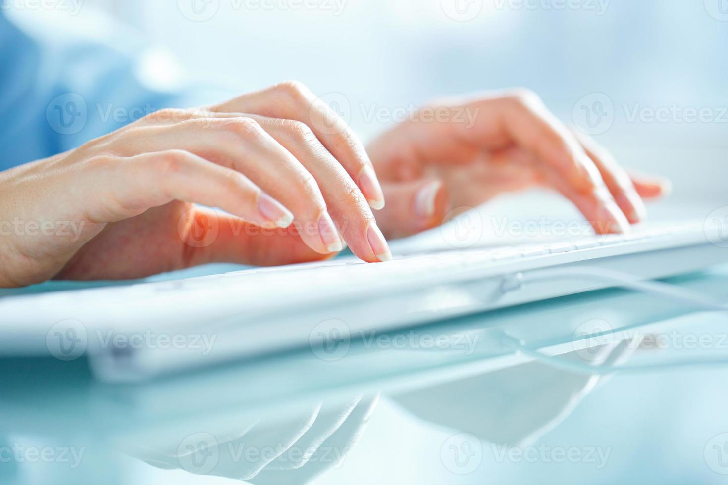 Woman office worker typing on the keyboard photo