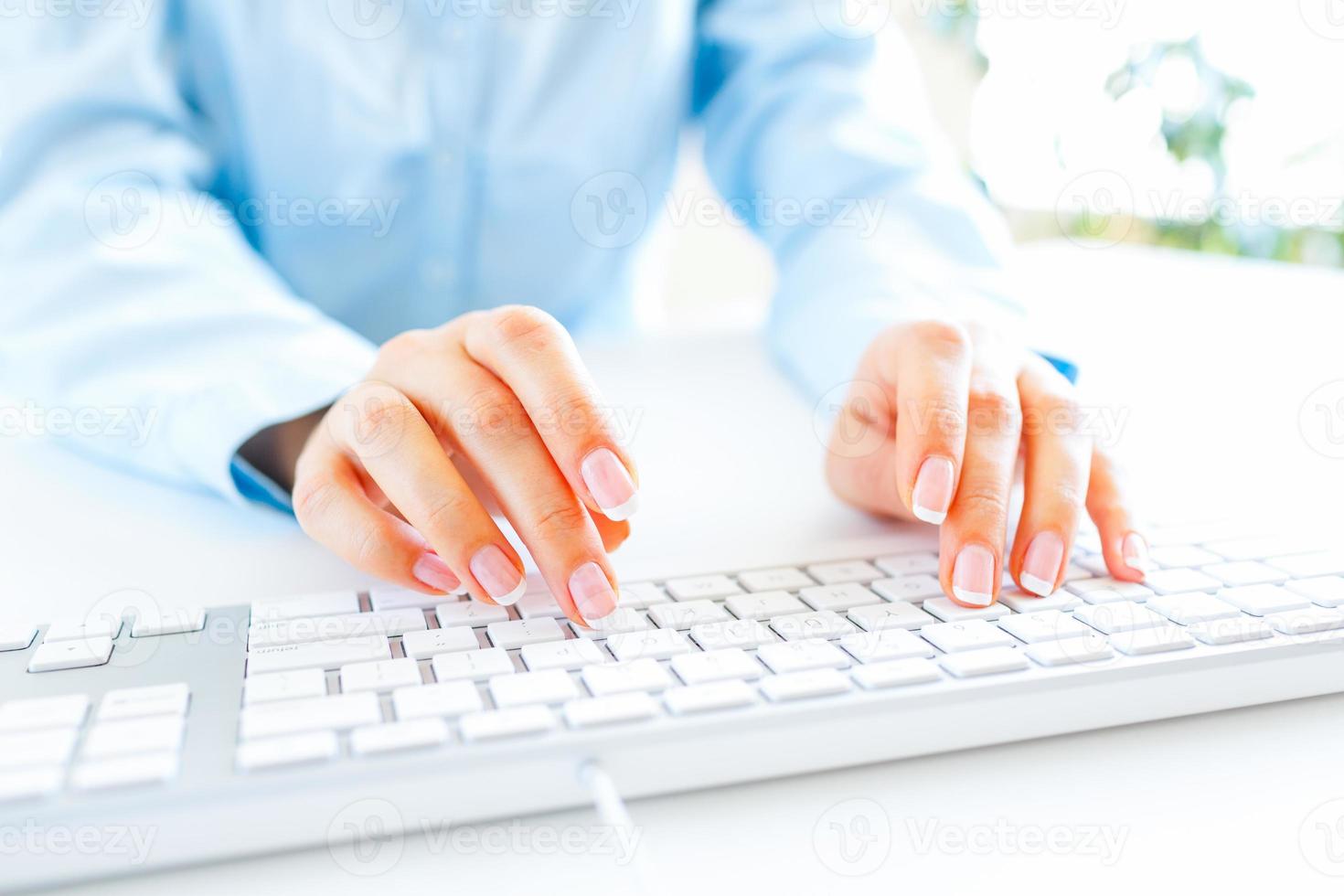 Woman office worker typing on the keyboard photo