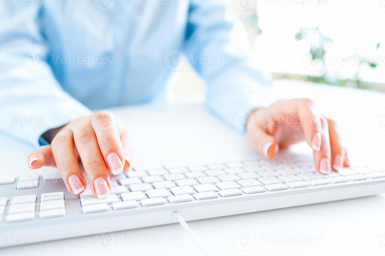 Woman office worker typing on the keyboard photo