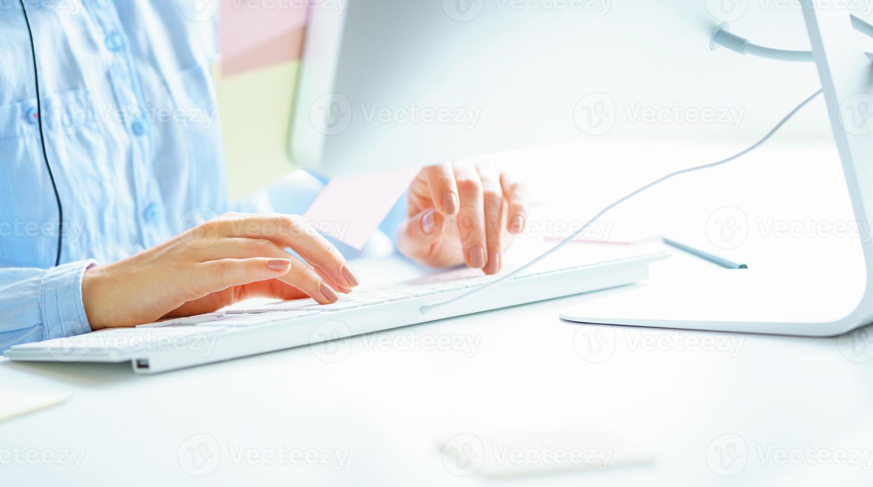 Woman office worker typing on the keyboard photo