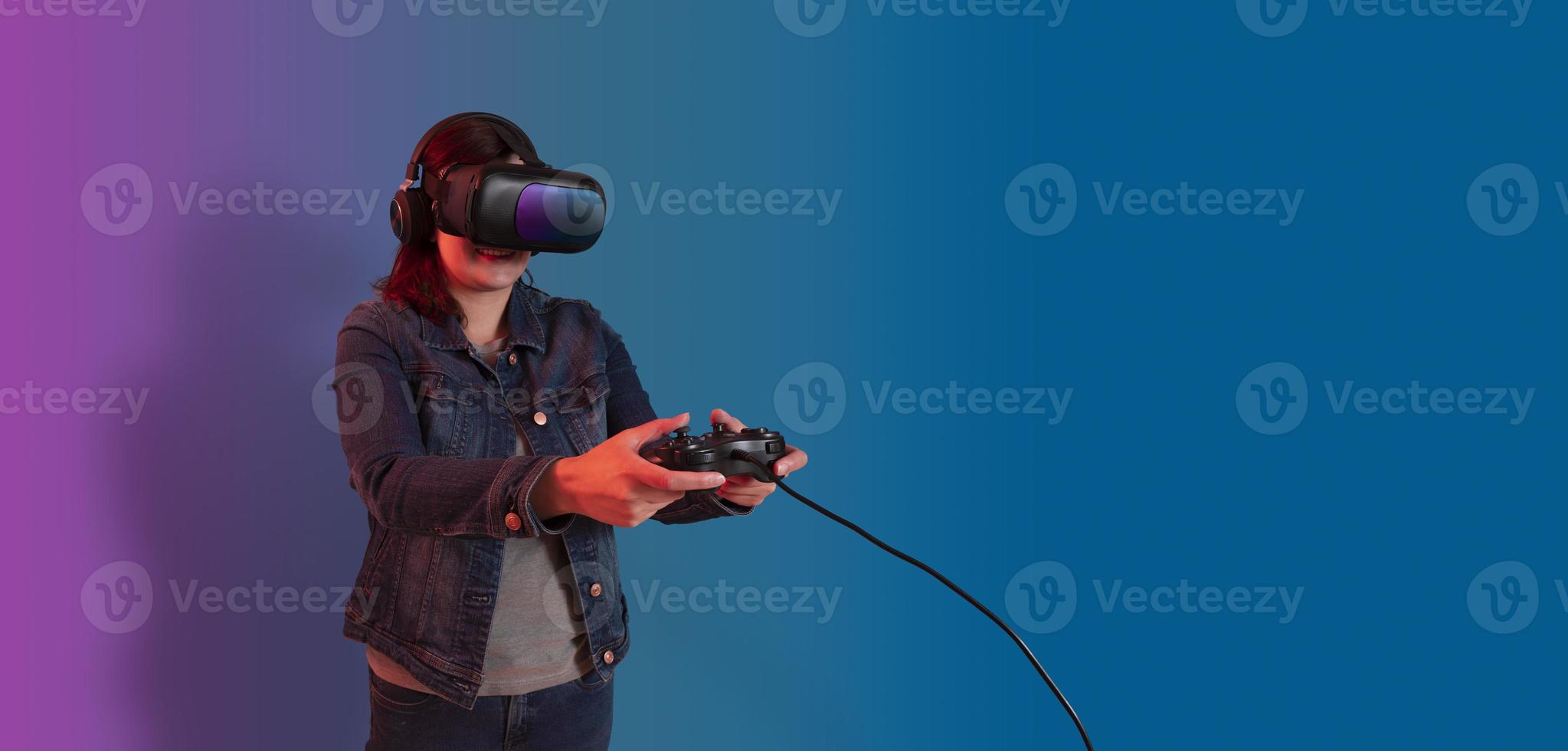 Beautiful young hispanic woman standing wearing virtual reality glasses and playing with a video game console in her hands photo