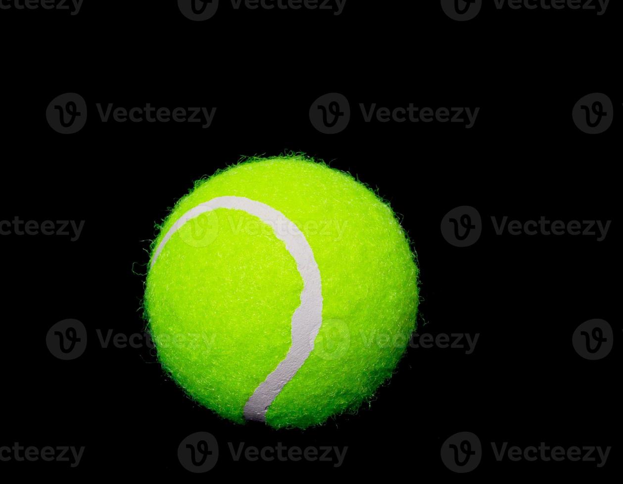 Tennis ball on black background photo