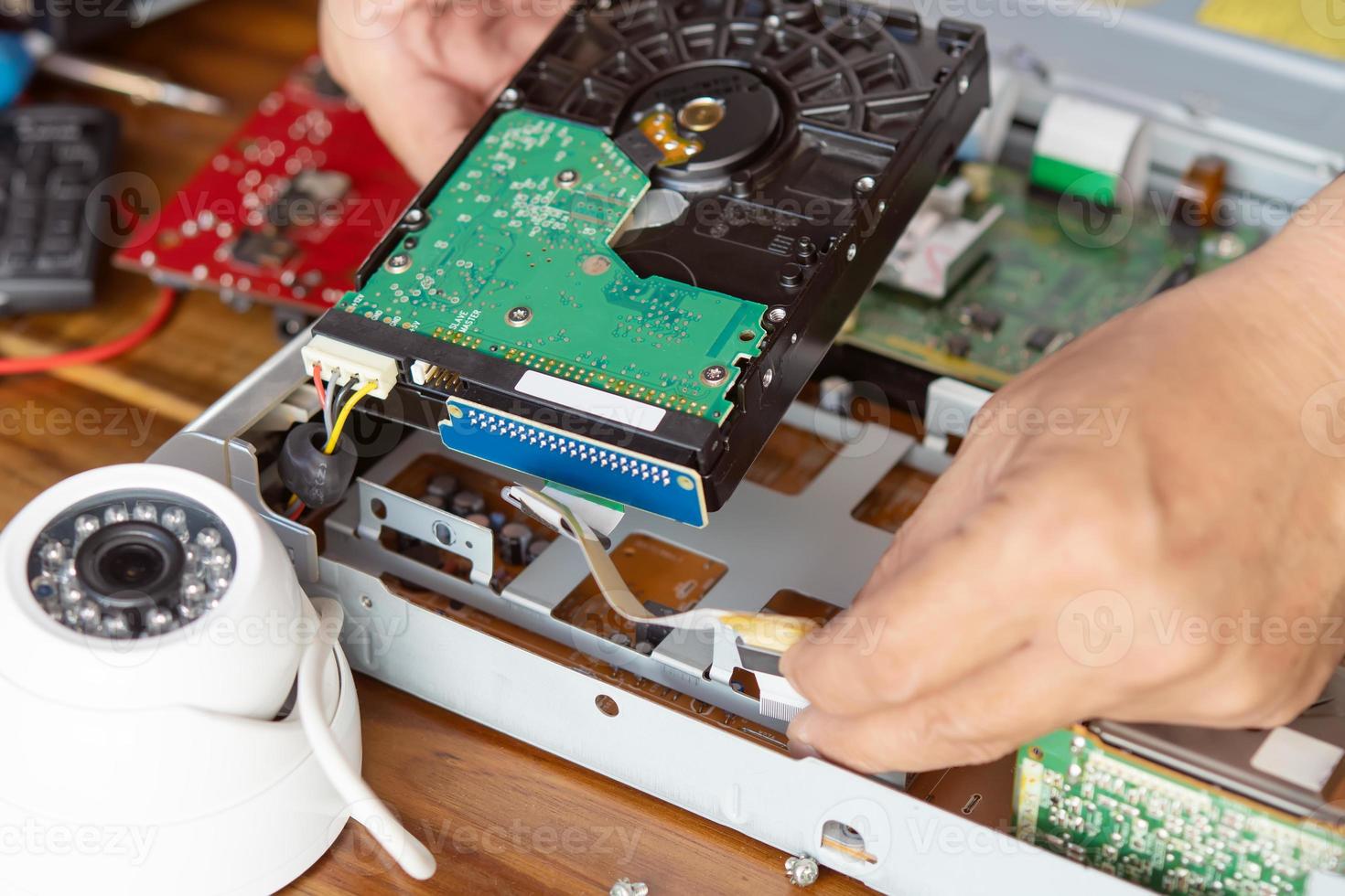 Technician remove a hard disk drive from the CCTV DVR recorder case, to install a new hard drive and upgrading to a Solid State for backup CCTV camera , electrical work and cctv concept photo