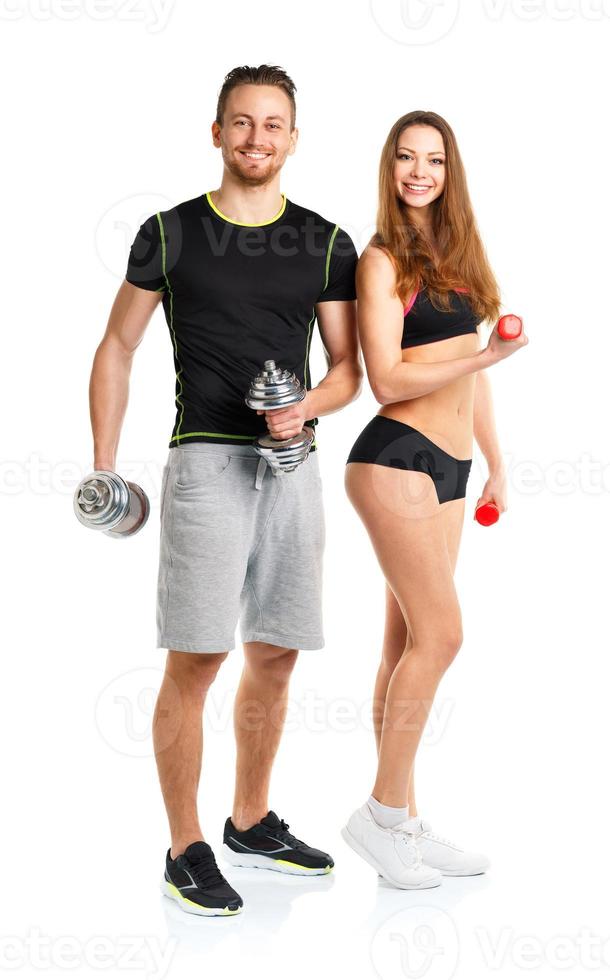 Athletic man and woman with dumbbells on the white photo