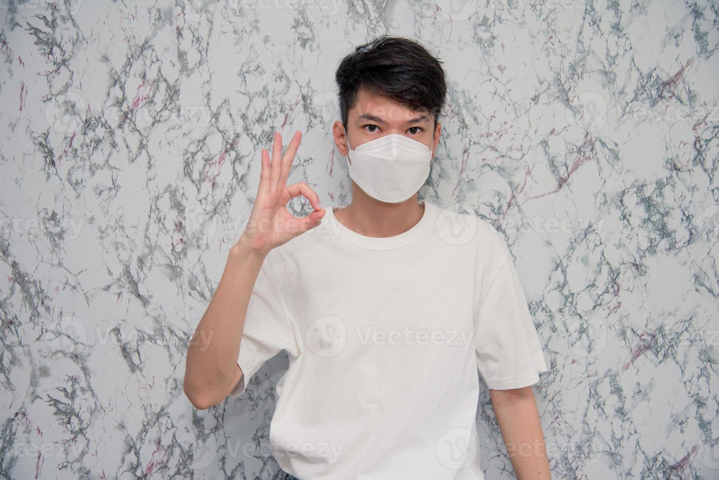 Handsome man showing okay gesture isolated on White background,protecting from virus during quarantine. Covid-19 photo