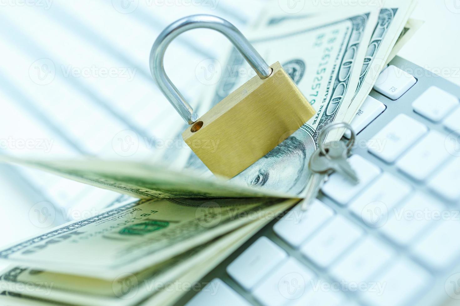 Security lock on dollar bills with white computer keyboard photo