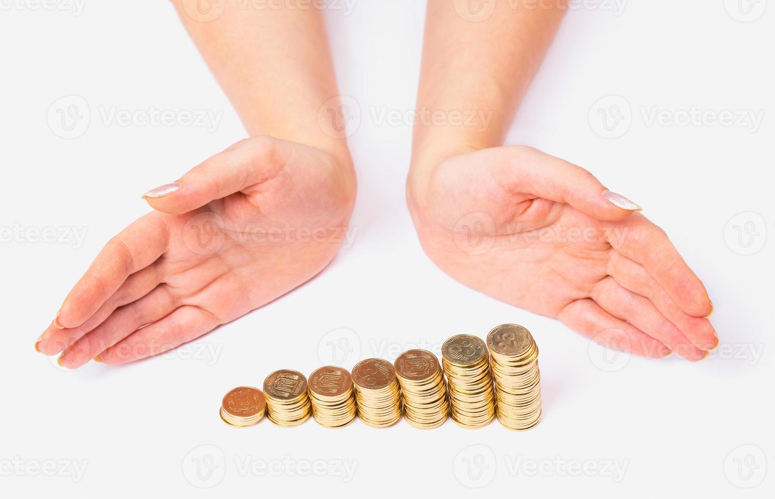 Womens arms around columns of coins photo