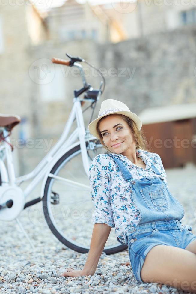 Happy woman with bicycle on the beach photo