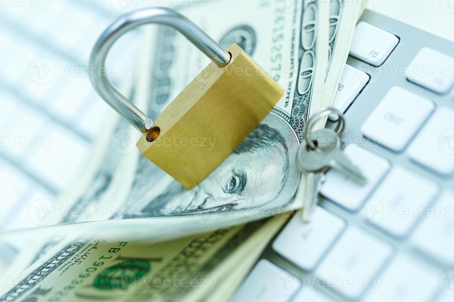 Security lock on dollar bills with white computer keyboard photo