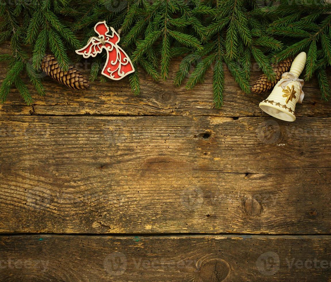 Christmas tree branches with cones and christmas decorations on wooden texture ready for your design photo