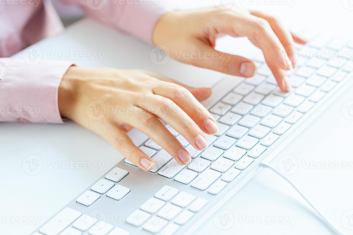 Woman office worker typing on the keyboard photo