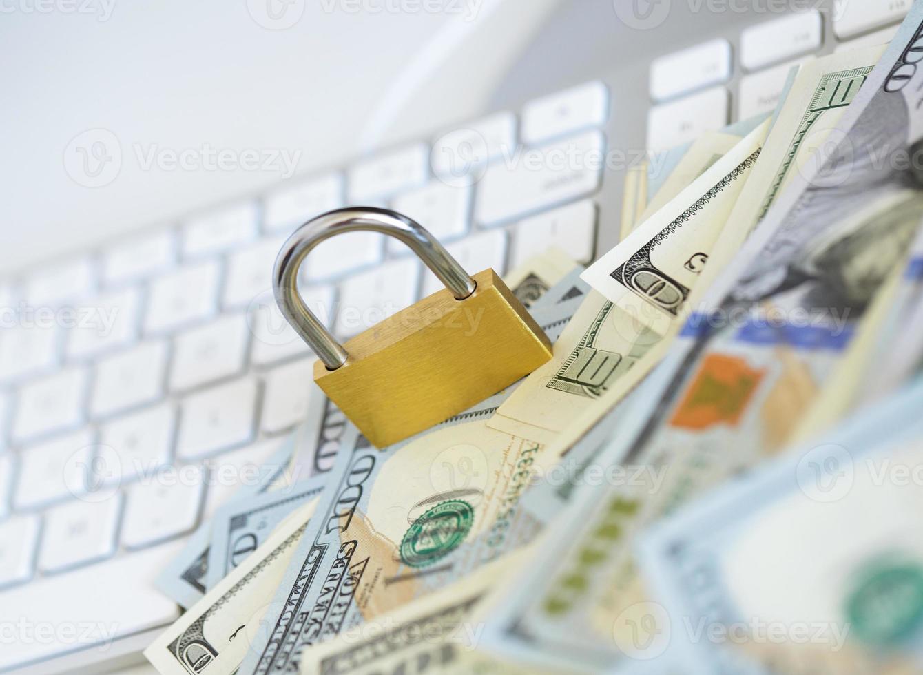 Security lock on dollar bills with white computer keyboard photo