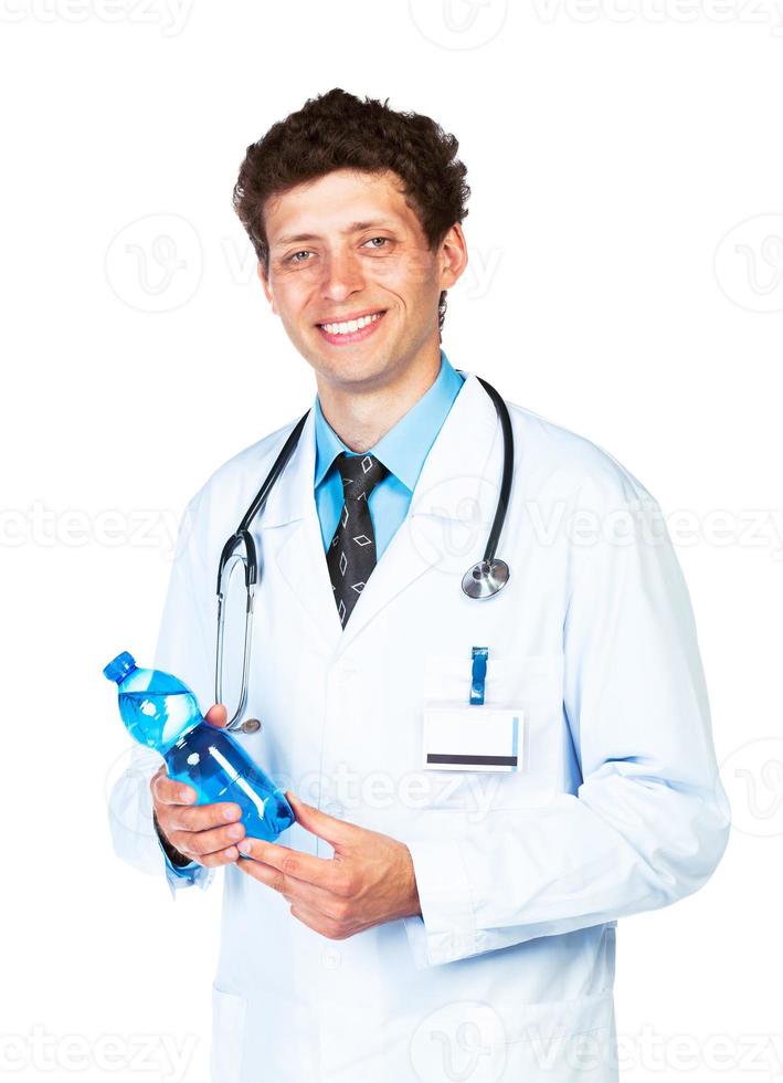 retrato de un sonriente masculino médico participación botella de agua en blanco foto