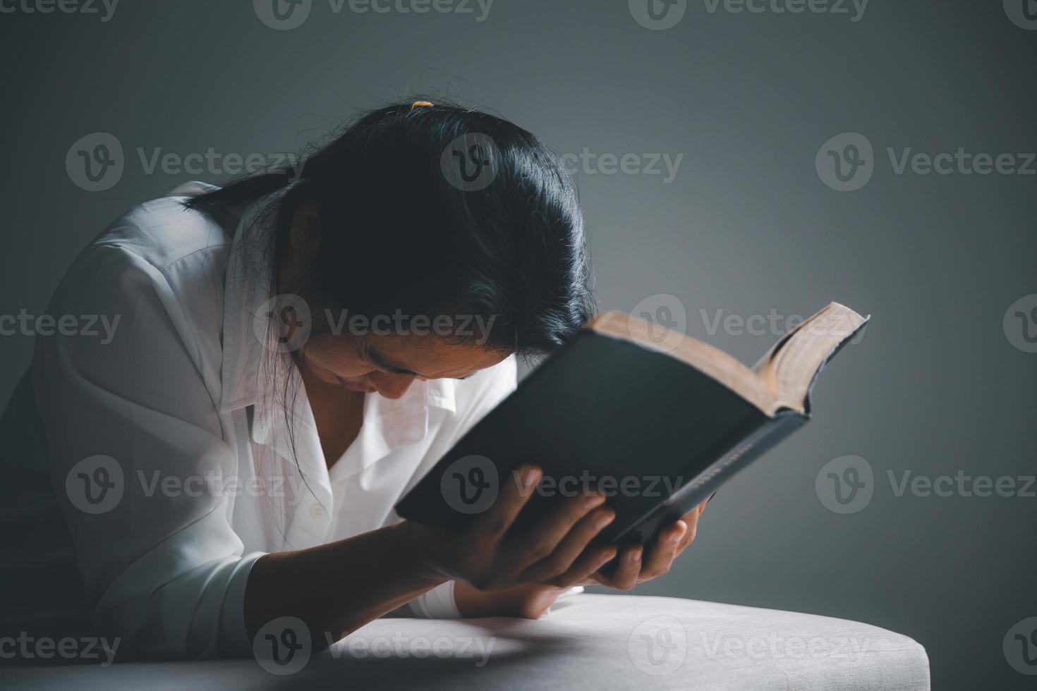 woman kneeling and praying in modern house at sunset time. Female catholic prayer worship to God wish a better life in home at dawn with believe faith. concept of worshipers kneeling. photo