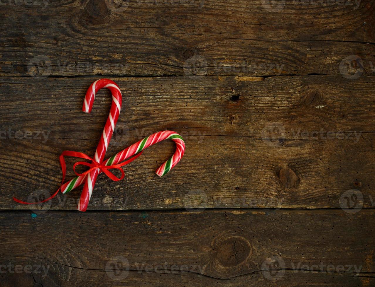 Closeup of two old fashioned candy canes on a rustic wooden background photo