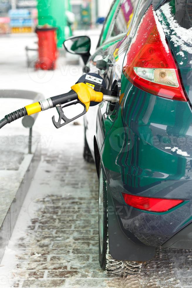 Car refueling on a petrol station in winter close up photo