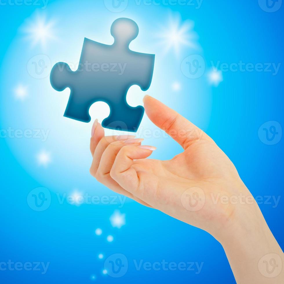 Womanish hand with a blue puzzle photo