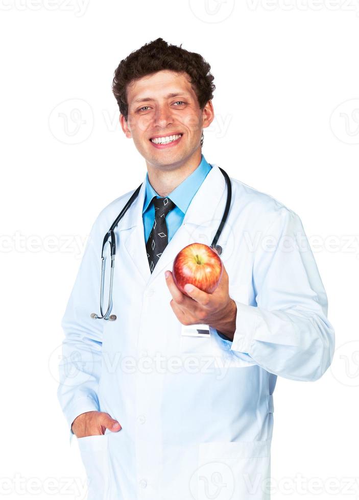 Smiling doctor holding red apple on white photo