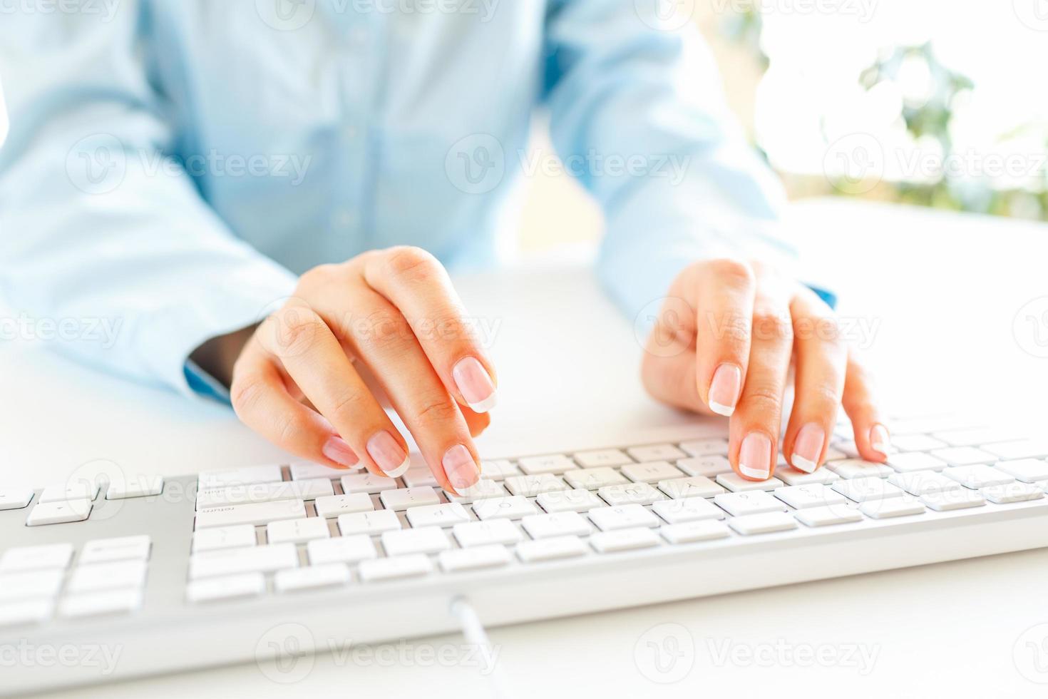 Woman office worker typing on the keyboard photo