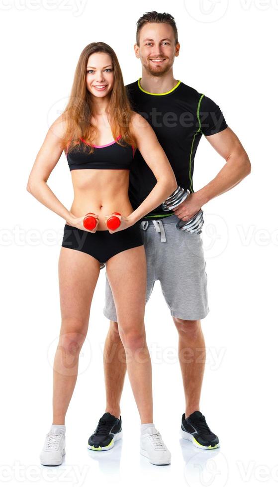 Athletic man and woman with dumbbells on the white photo