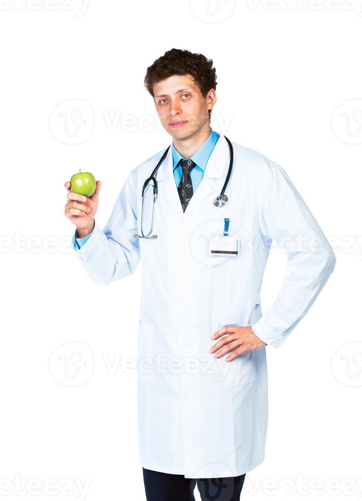 Portrait of a male doctor holding green apple on white photo