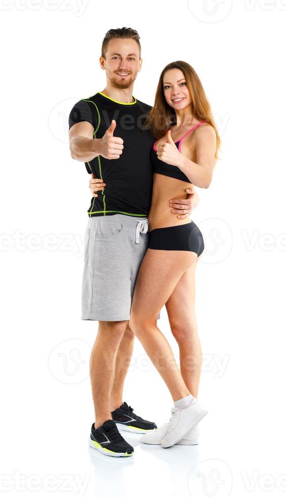 Athletic man and woman after fitness exercise with thumbs up on the white photo