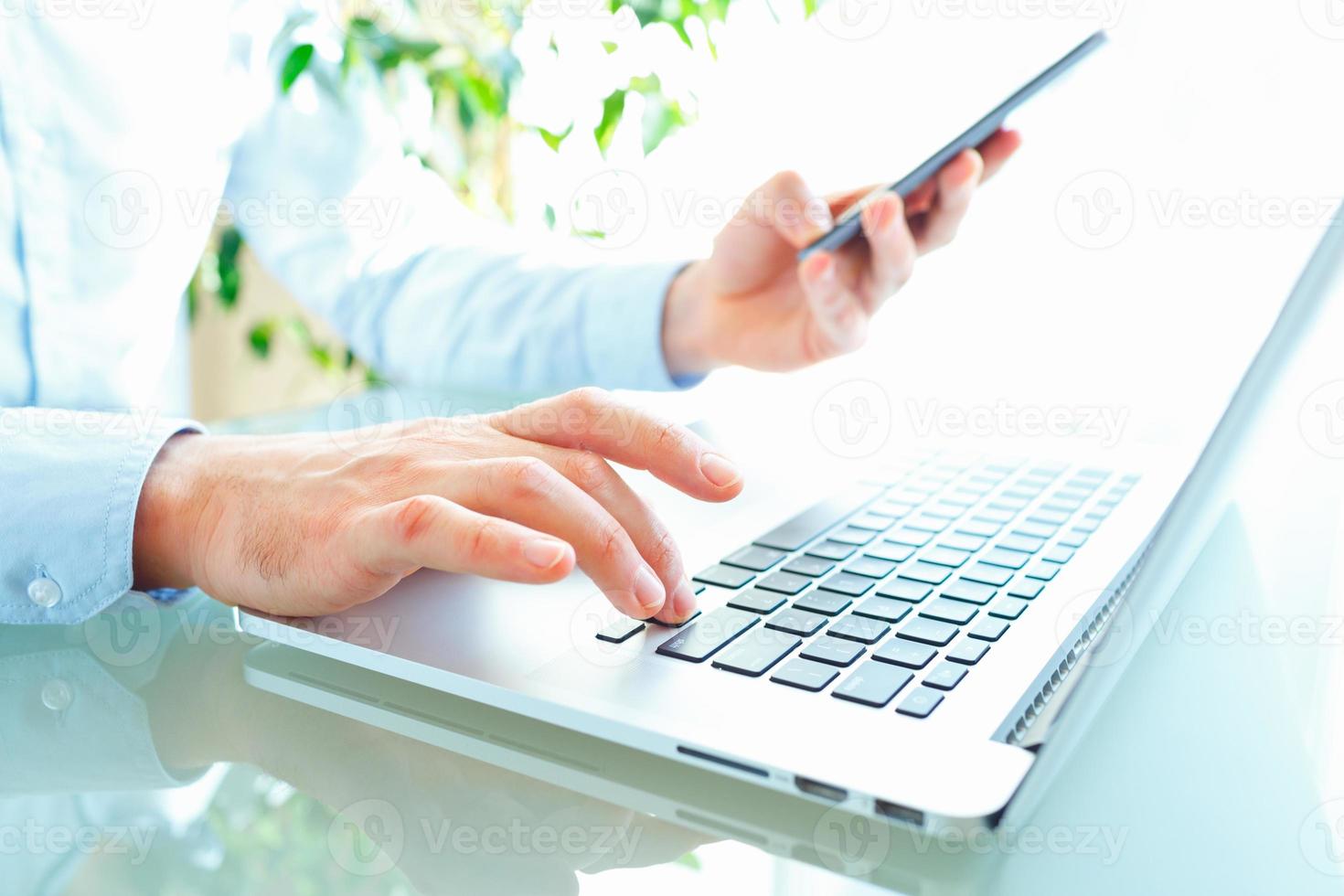 manos o hombres oficina trabajador mecanografía en el teclado y utilizando teléfono inteligente foto