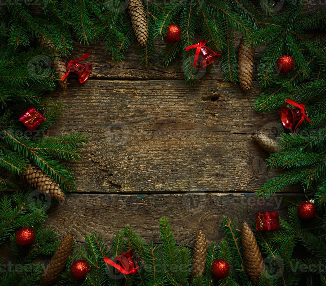 Christmas tree branches with cones and christmas decorations on wooden texture ready for your design photo