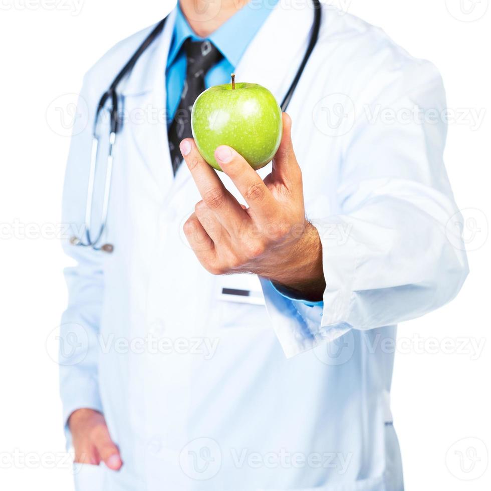 Doctor's hand holding a fresh green apple close-up on white photo