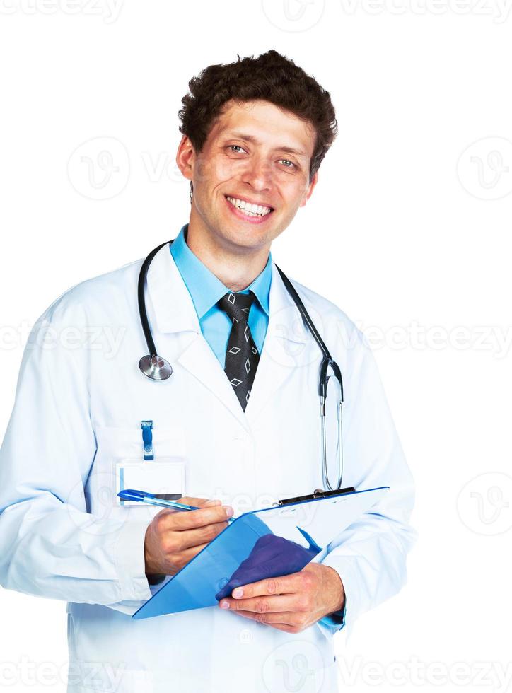 Portrait of smiling young male doctor writing on a patient's medical chart on white photo