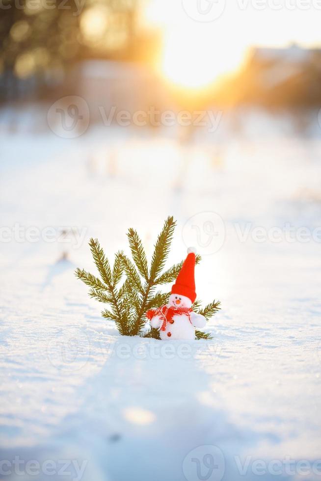 Happy snowman standing in winter christmas landscape photo