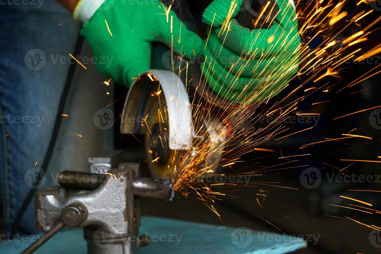 Worker with angular grinding machine is cutting the metal photo
