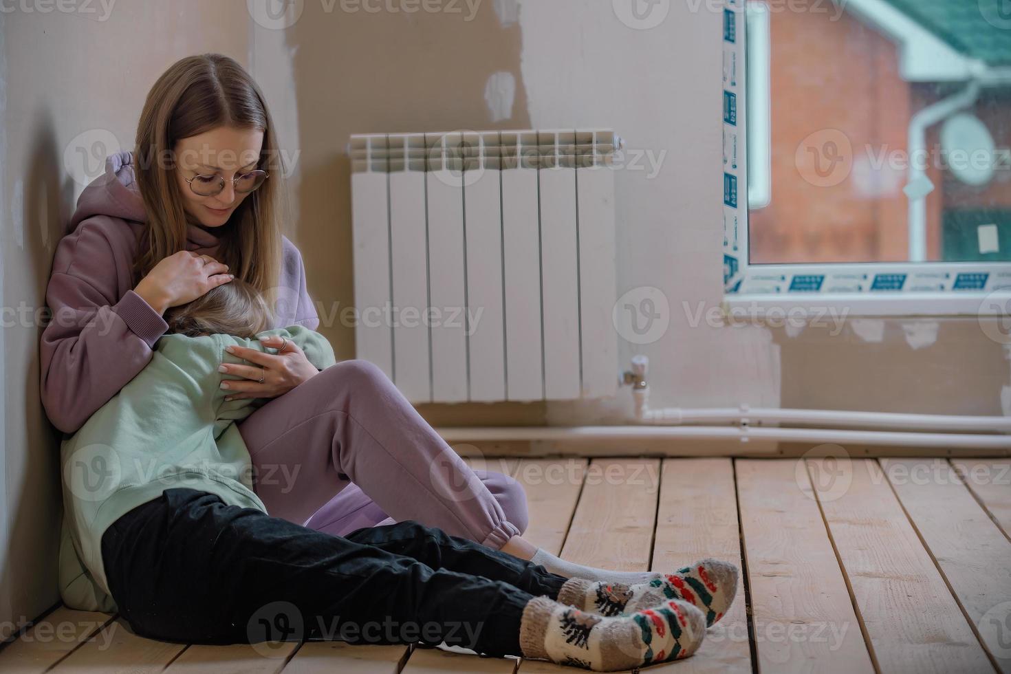 mother sits with her ten-year-old daughter in the attic of the house, the girl is upset, her mother hugged her and calms her down. difficult age and problems at school in children photo