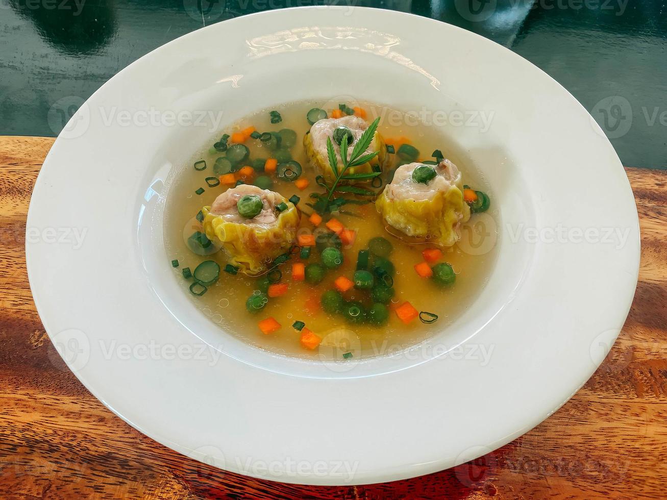 hotel resort food Asian style dumpling in clear chicken consomme soup with scallion photo