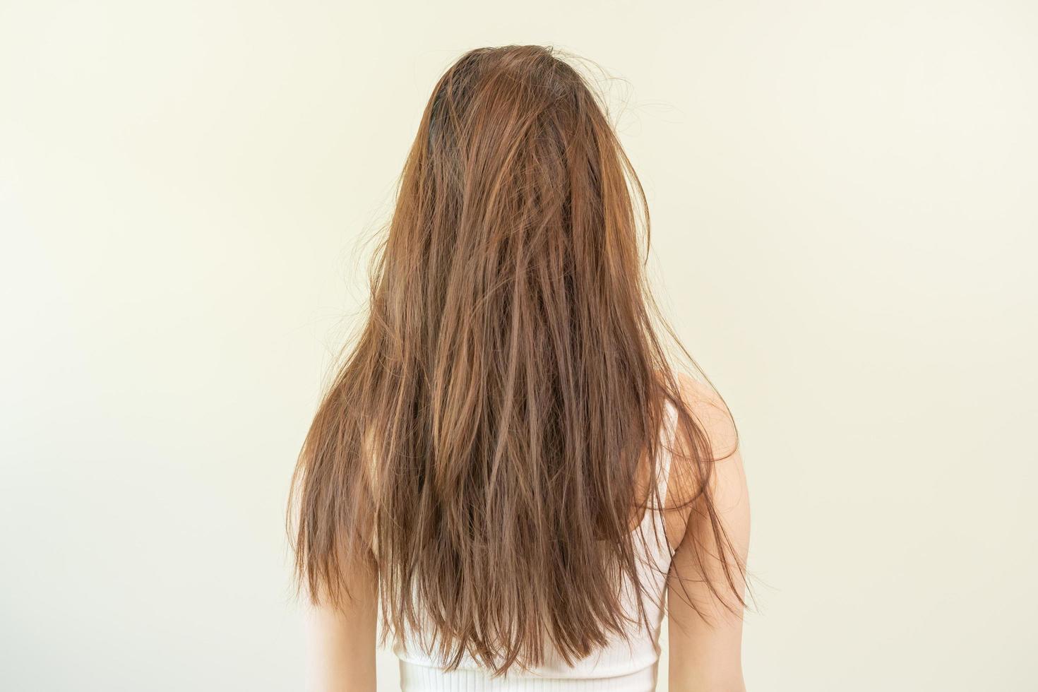 Damaged hair, frustrated asian young woman, girl in splitting ends, messy unbrushed dry hair and frizzy with long disheveled hair, health care of beauty. Portrait isolated on background, Back view. photo