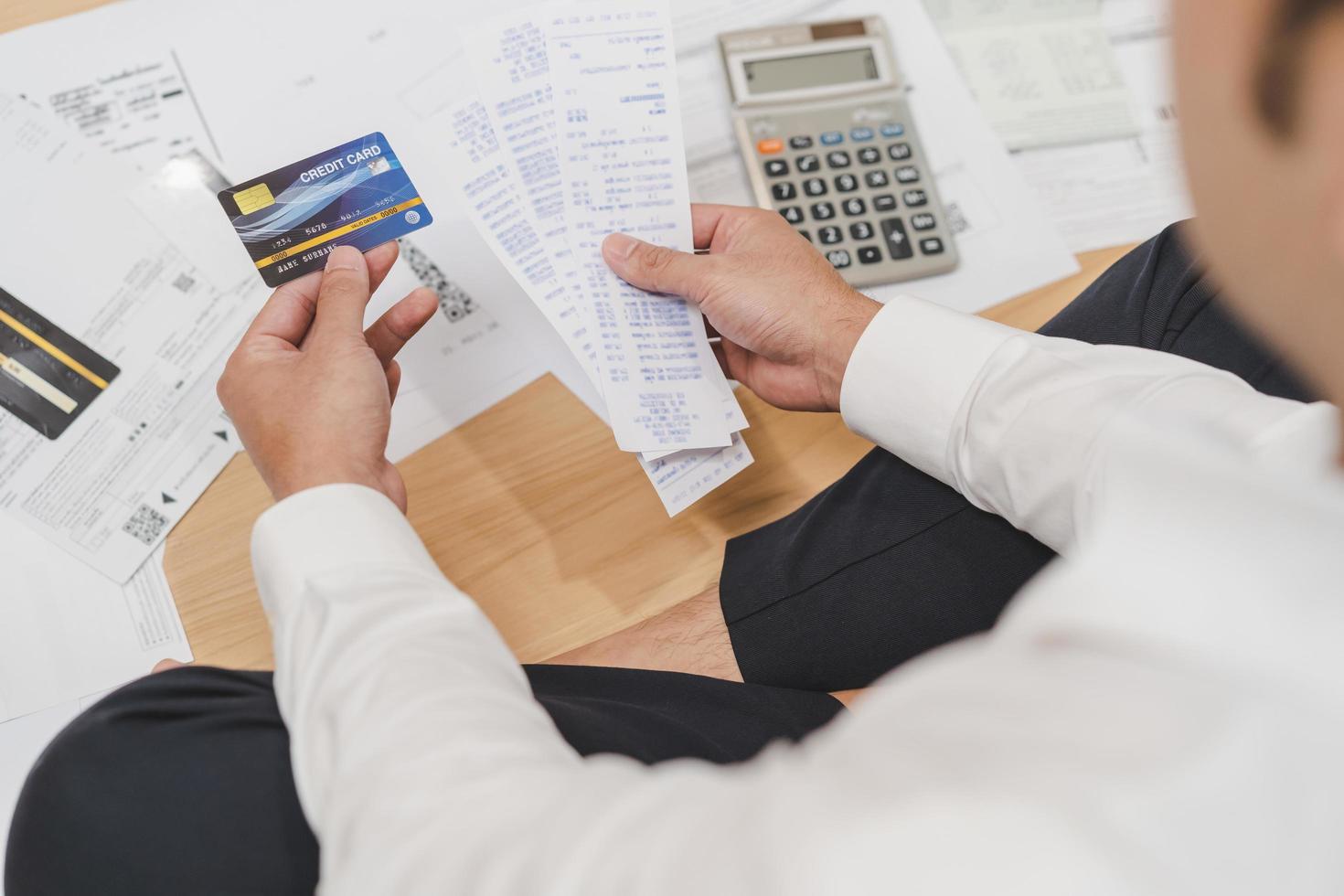 parte superior ver financiero deber asiático joven hombre sentado sufrir, estresado y confuso por calcular gastos desde factura, crédito tarjeta cuenta No dinero a pagar hipoteca o préstamo. deuda, arruinado o arruinado gente. foto