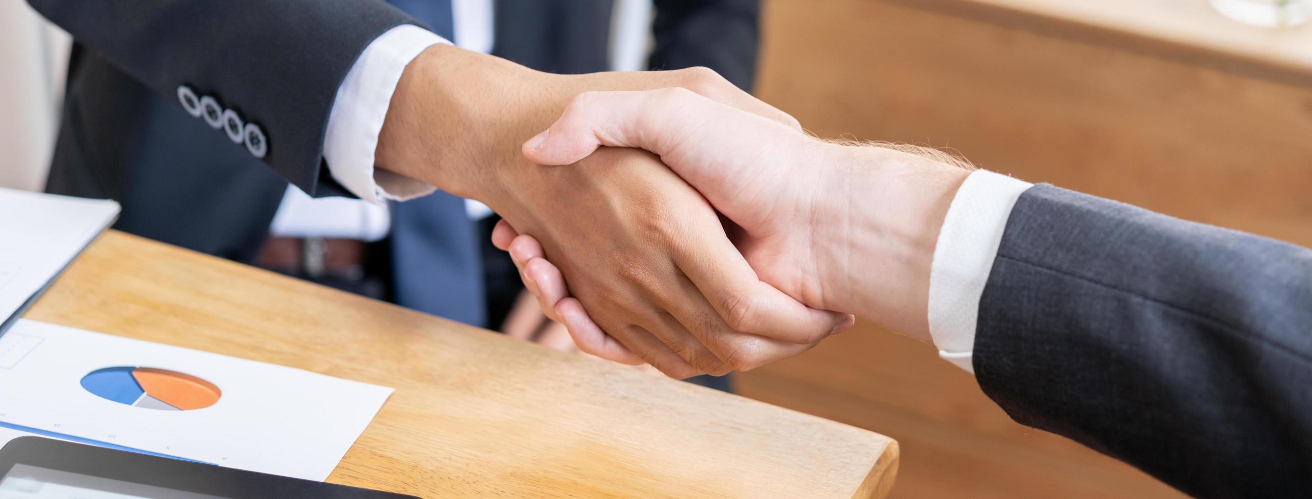 Support, business people, happy asian young man in suit, making handshake, shake hand together with partnership, customer or colleague after is done, successful. Worker meeting, congrats merger. photo