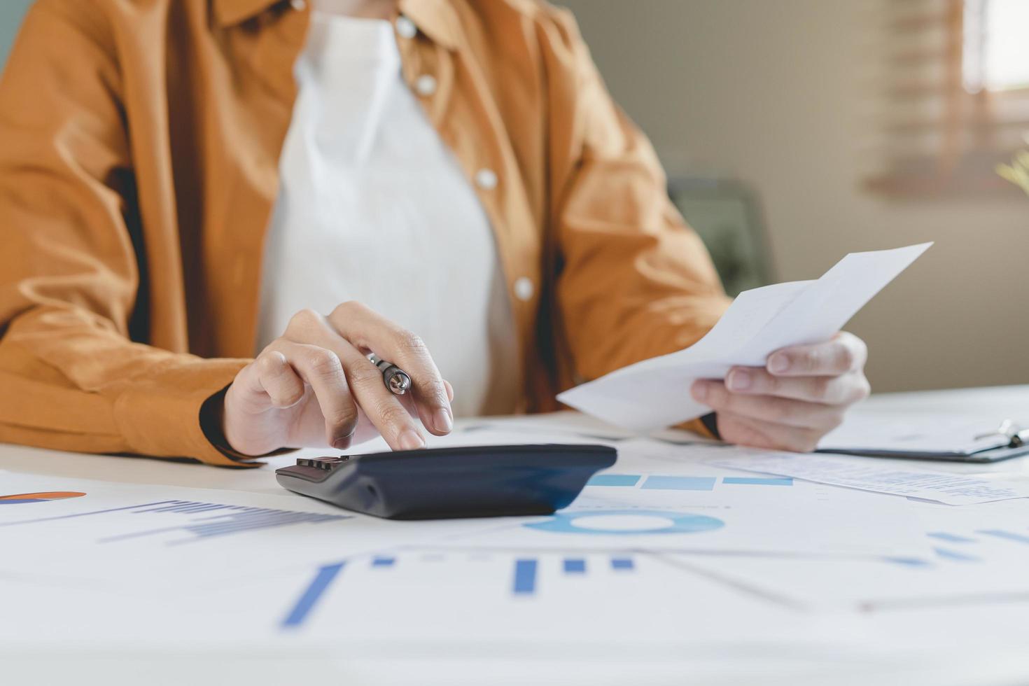 cerca arriba mano de estrés asiático joven empleado negocio mujer calcular impuesto ingresos y gastos, facturas, crédito tarjeta para pago o día de paga en mesa a hogar oficina. financiero, Finanzas personas concepto. foto