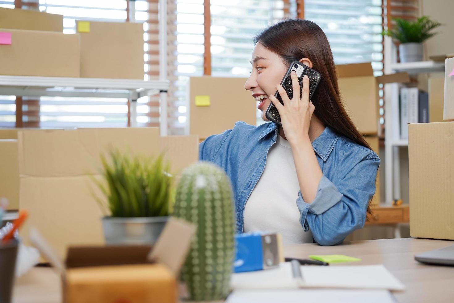 pequeño negocio empresario pequeño, asiático joven mujer propietario embalaje producto, comprobación paquete o empaquetar caja entrega, utilizando ordenador portátil recibir orden desde cliente, trabajando a hogar oficina. comerciante en línea, comercio electrónico foto