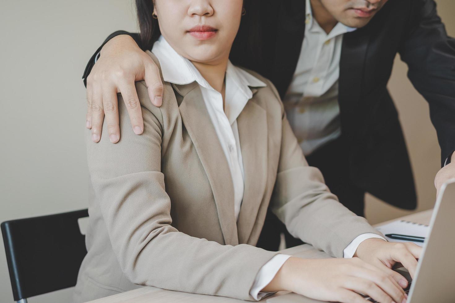 infeliz asiático joven mujer empleado, hombre empleador, colega o jefe conmovedor a su hombro sensación disgustado, incómodo. sexual acoso inapropiado de negocio personas a oficina, lugar de trabajo. foto