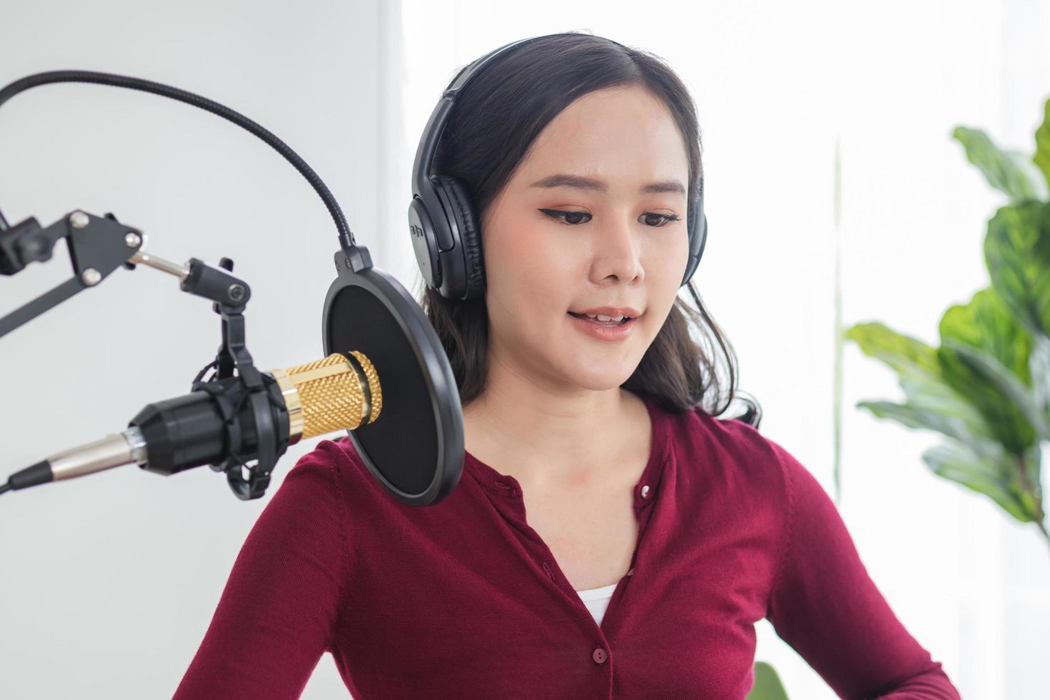 hermosa asiático joven mujer radio anfitrión trabajando en auriculares, micrófono mientras hablar, conversacion y grabación podcast, En Vivo en social medios.tecnologia de al aire en línea en radiodifusión a estudio. foto