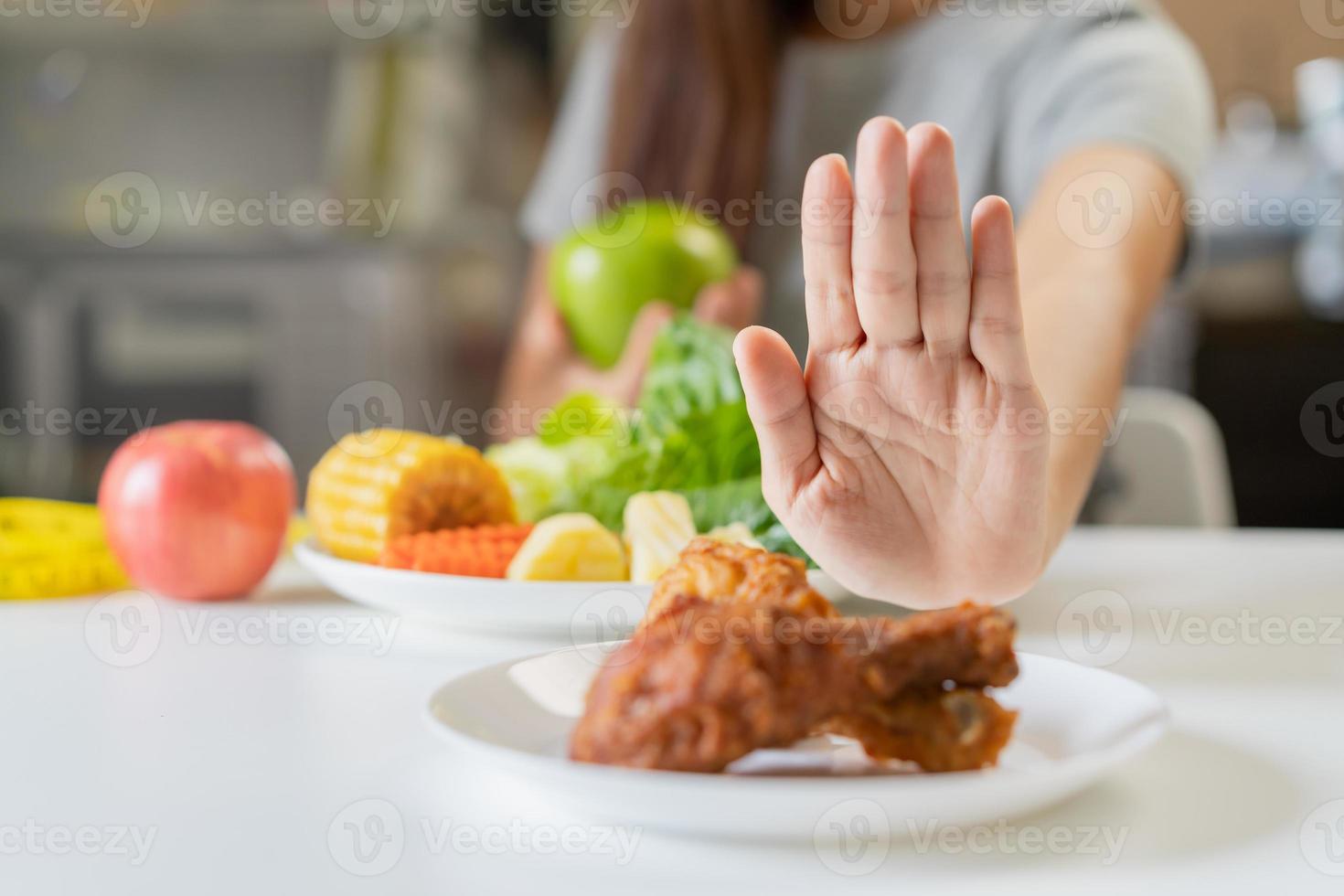 dieta, dieta asiático joven mujer o niña empujar afuera, negar frito pollo, basura comida y escoger verde manzana, vegetales ensalada, comer comida para bueno saludable, salud cuando hambriento. hembra peso pérdida gente. foto