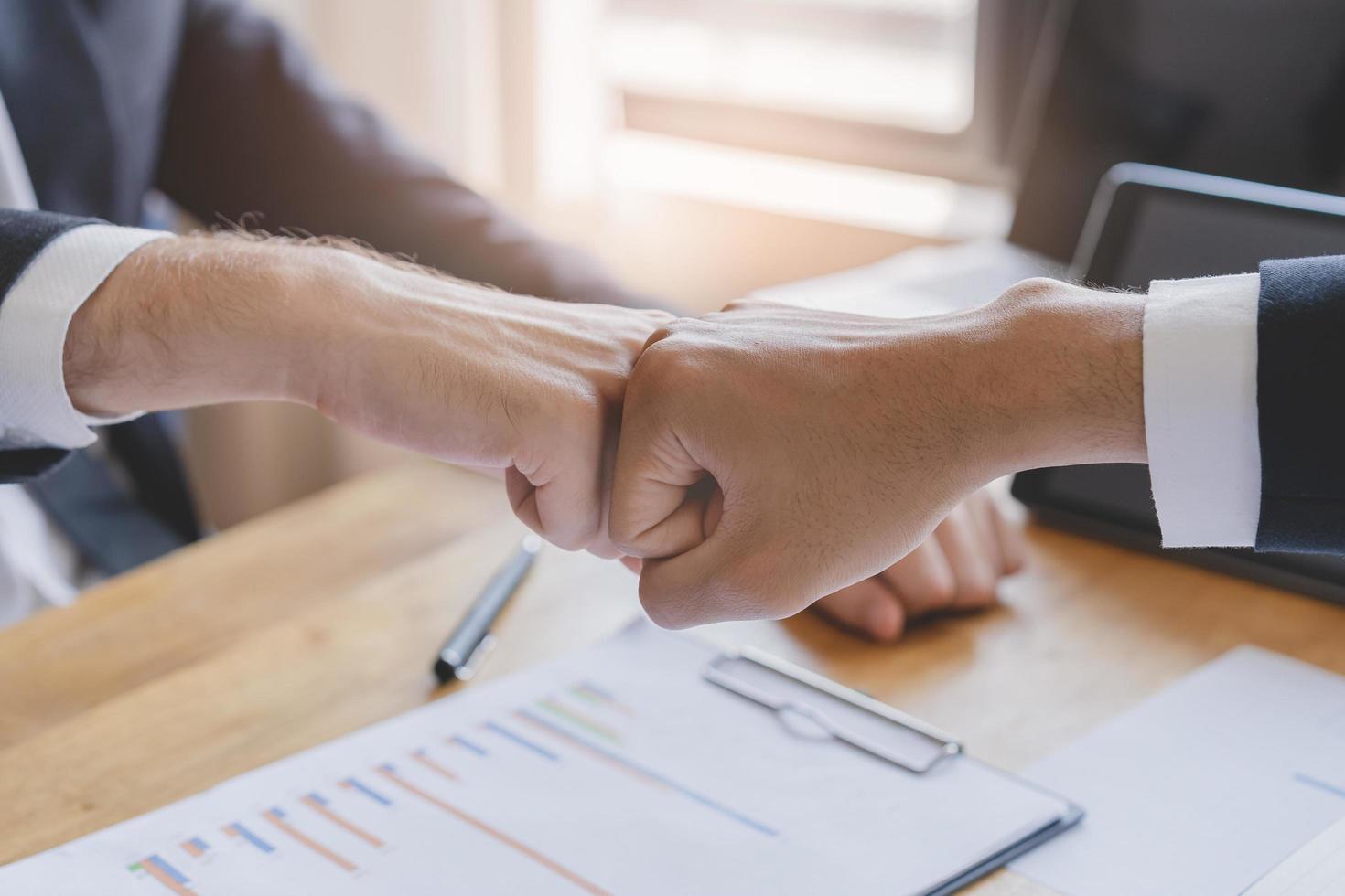 Congrats, business partnership people, two asian and caucasian young man fist bumping, shaking hands together with partnership, customer or colleague after work is done, successful. Worker meeting. photo