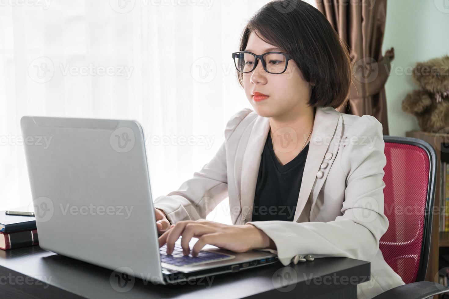 Woman working on laptop in home office photo