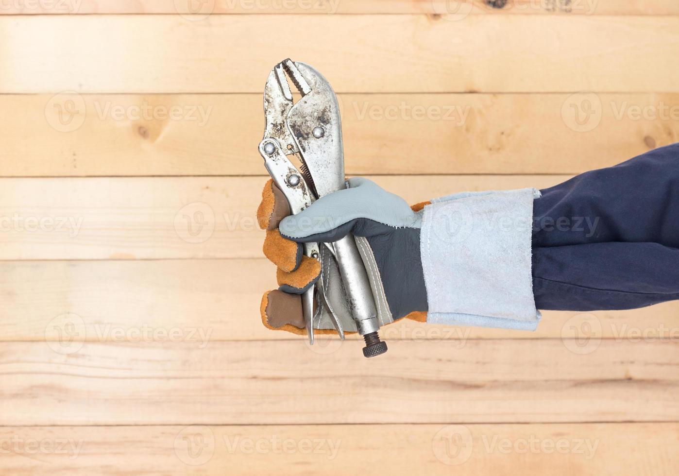 Hand in glove holding Adjustable wrench photo